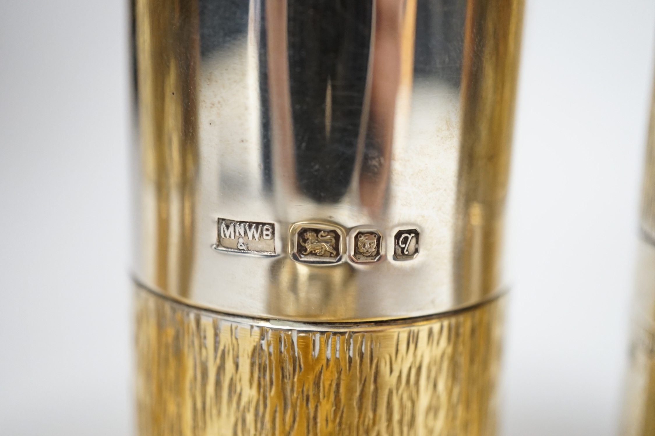 A suite of four Elizabeth II parcel gilt silver condiments, comprising a cylindrical salt, pepper and pepper grinder and a tub salt, Mappin & Webb, London, 1971, tallest 10.5cm.